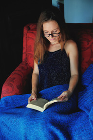 Cute Sofi Shane sits in an armchair reading