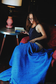 Cute Sofi Shane sits in an armchair reading